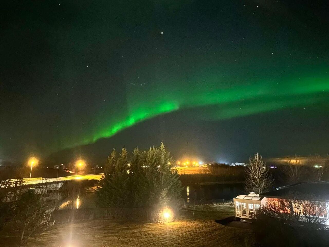 Northern lights over the lights of Hella and the river
