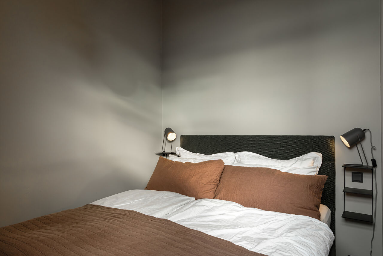A bedroom in grey and rust in the Penthouse