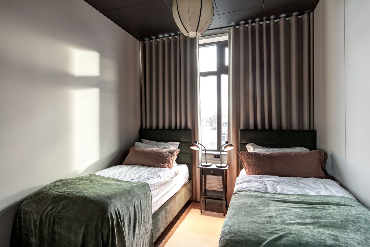 A bedroom in the Penthouse with a green throw