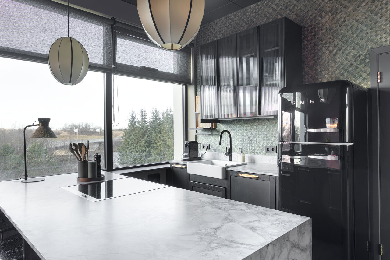 The marble kitchen island under rattan pendants