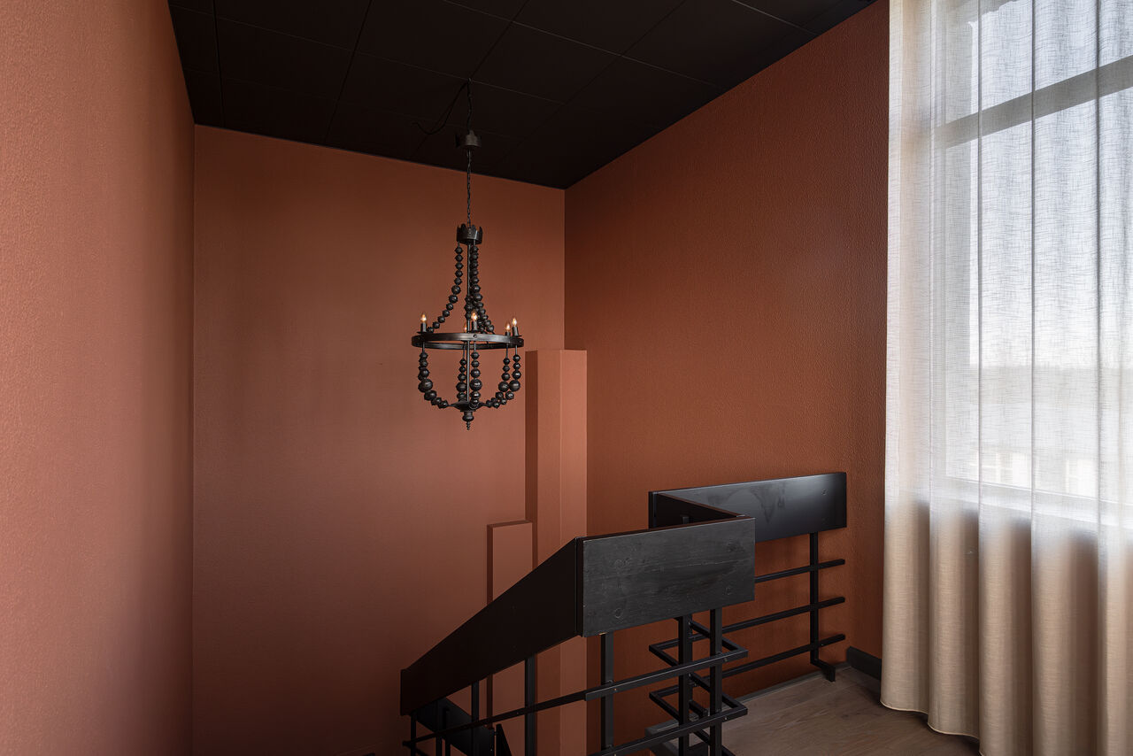 The terracotta stairwell with its black chandelier