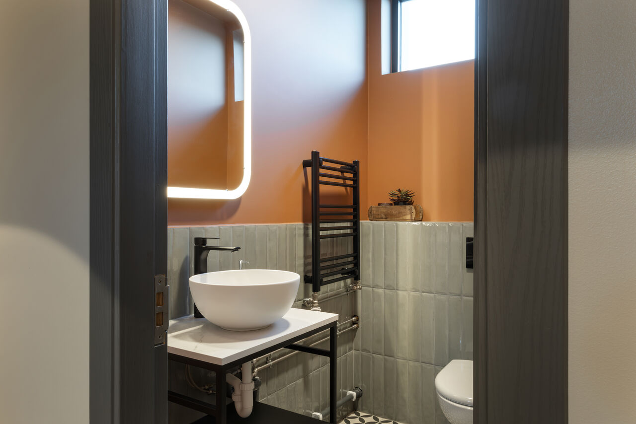 The second bathroom with a vessel sink and a backlit mirror