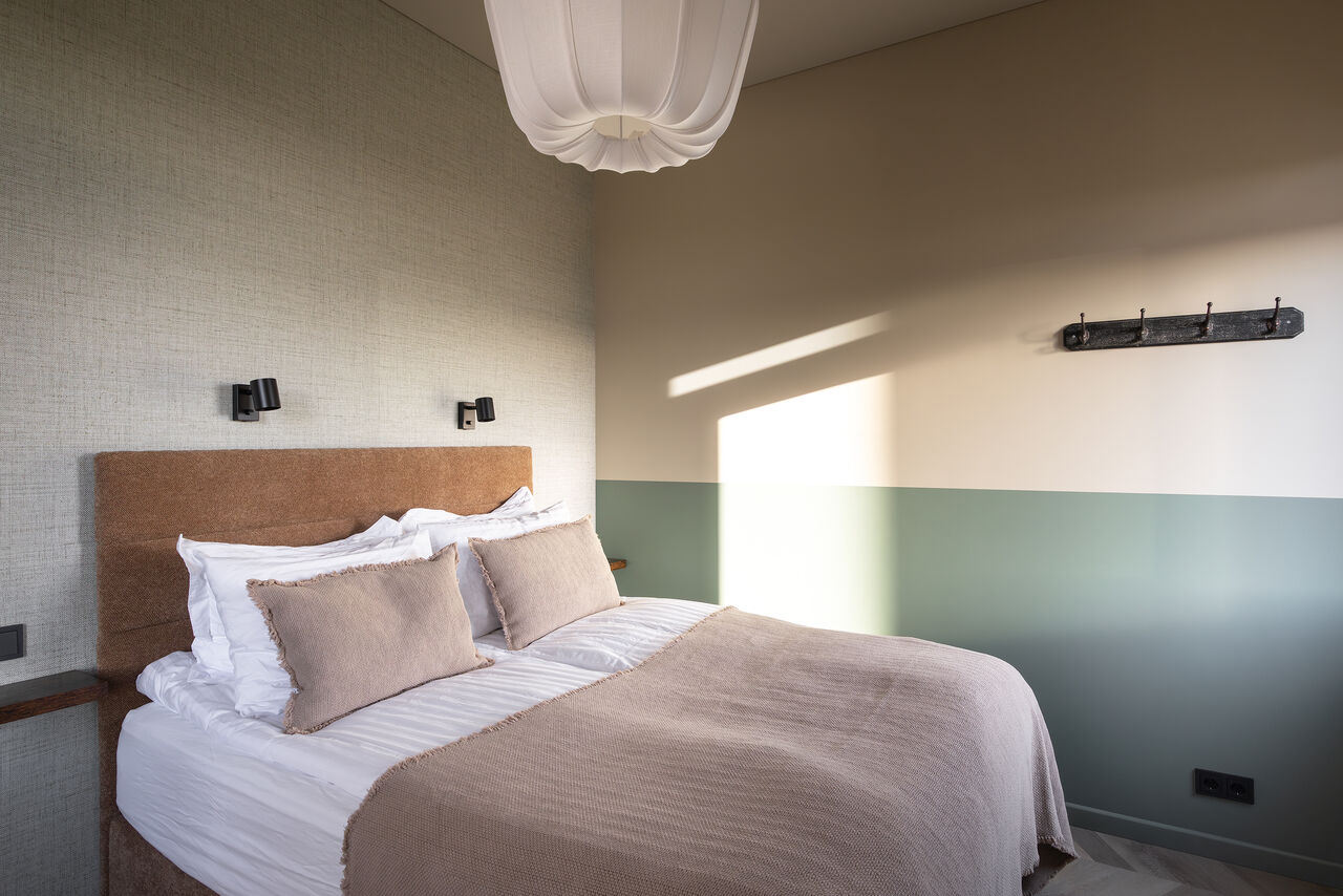 A one-bedroom apartment bedroom in sage and cream