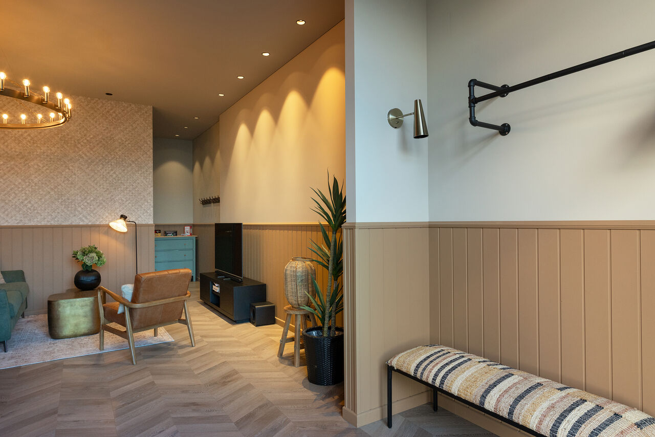 An entrance with a coat rail and bench, looking through to the living room