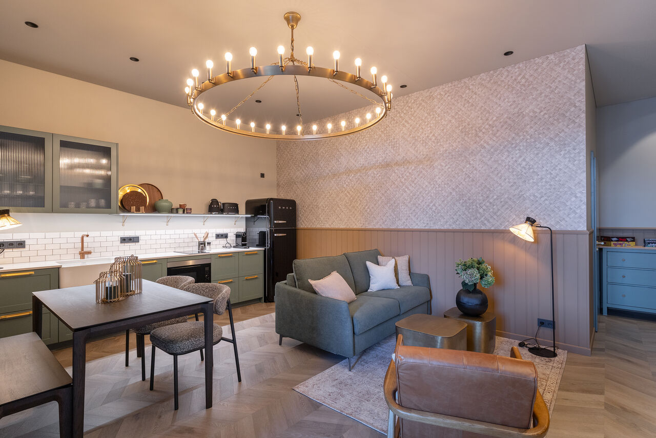 Apartment 1: the kitchen, dining table and sofa under a brass ring chandelier